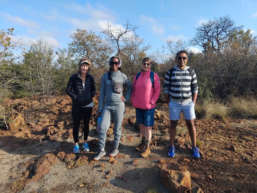 Hikers posing among the rocky terrain and indigenous vegetation at one of Klipriviersberg's scenic viewpoints.