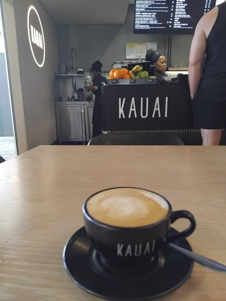 Cappuccino served in a black Kauai cup and saucer at the gym café.